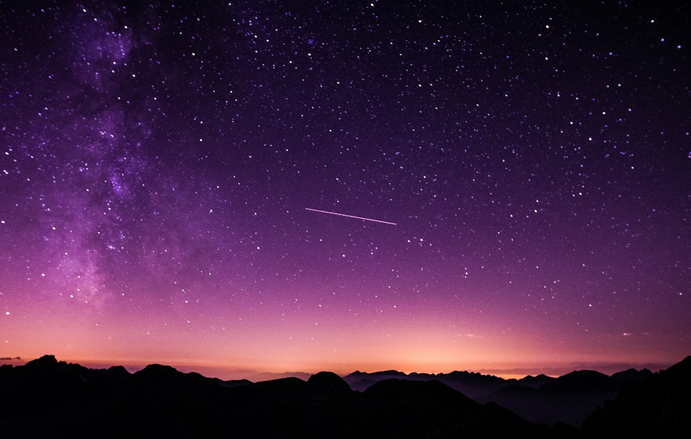 Purple Milky Way and stars above a mountain horizon at twilight