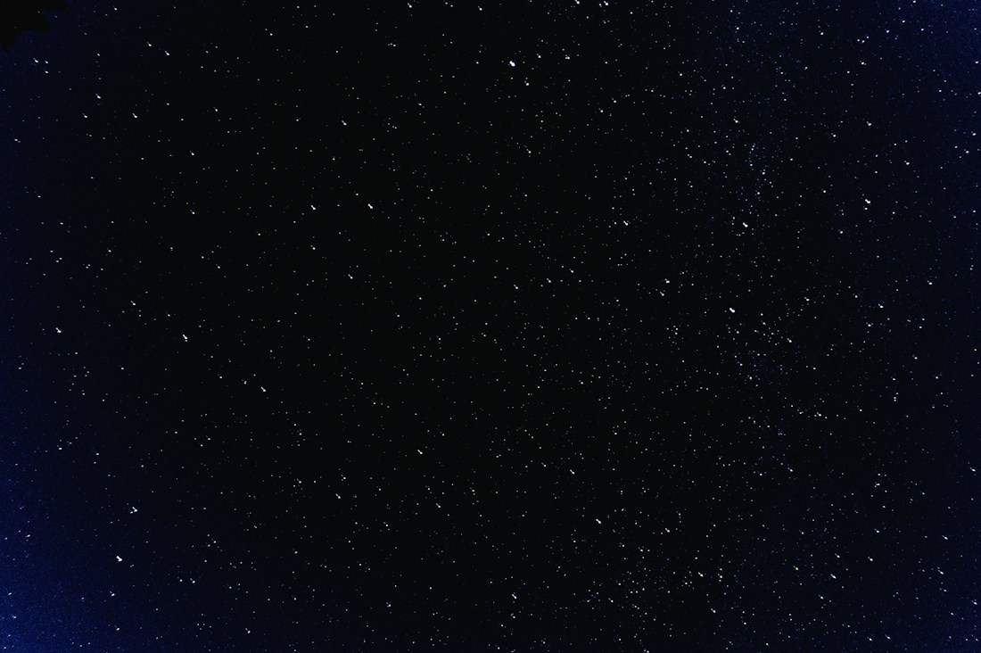 A field of stars scattered across a dark blue night sky